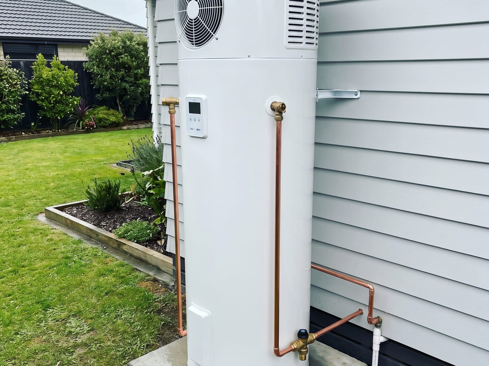 Heat pump hot water cylinder on a weatherboard home