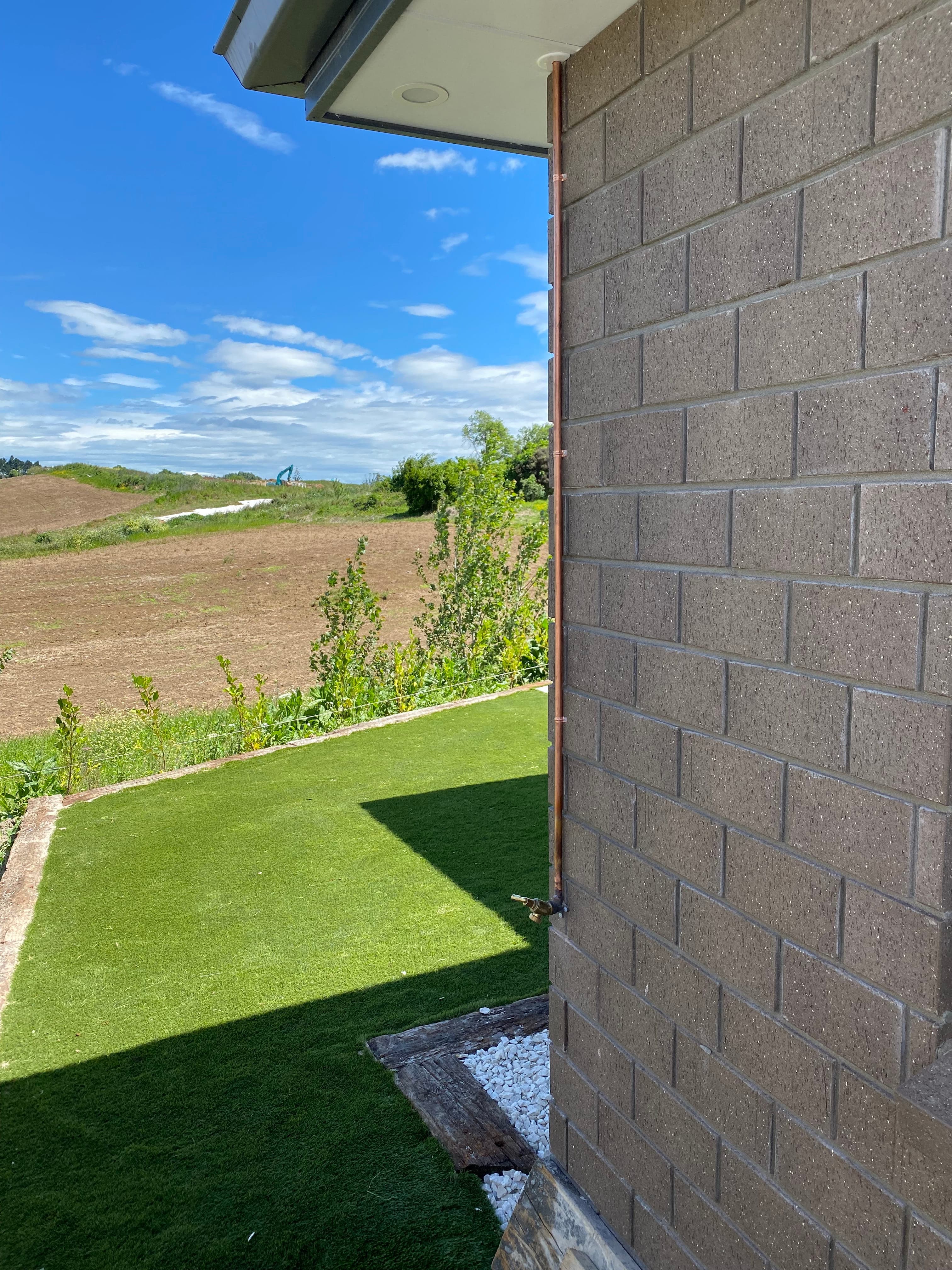 Exterior copper downpipe installation on new build by Plumbway Ltd