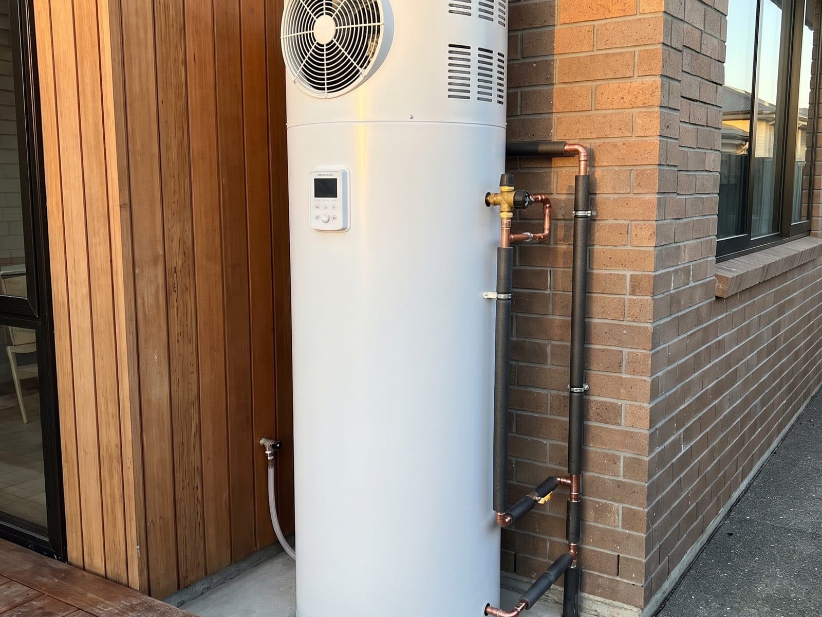 Heat pump hot water cylinder installed beside a Hamilton home